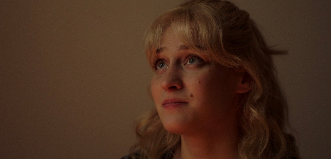 Lex Leone close up film still looking up with warm dramatic lighting