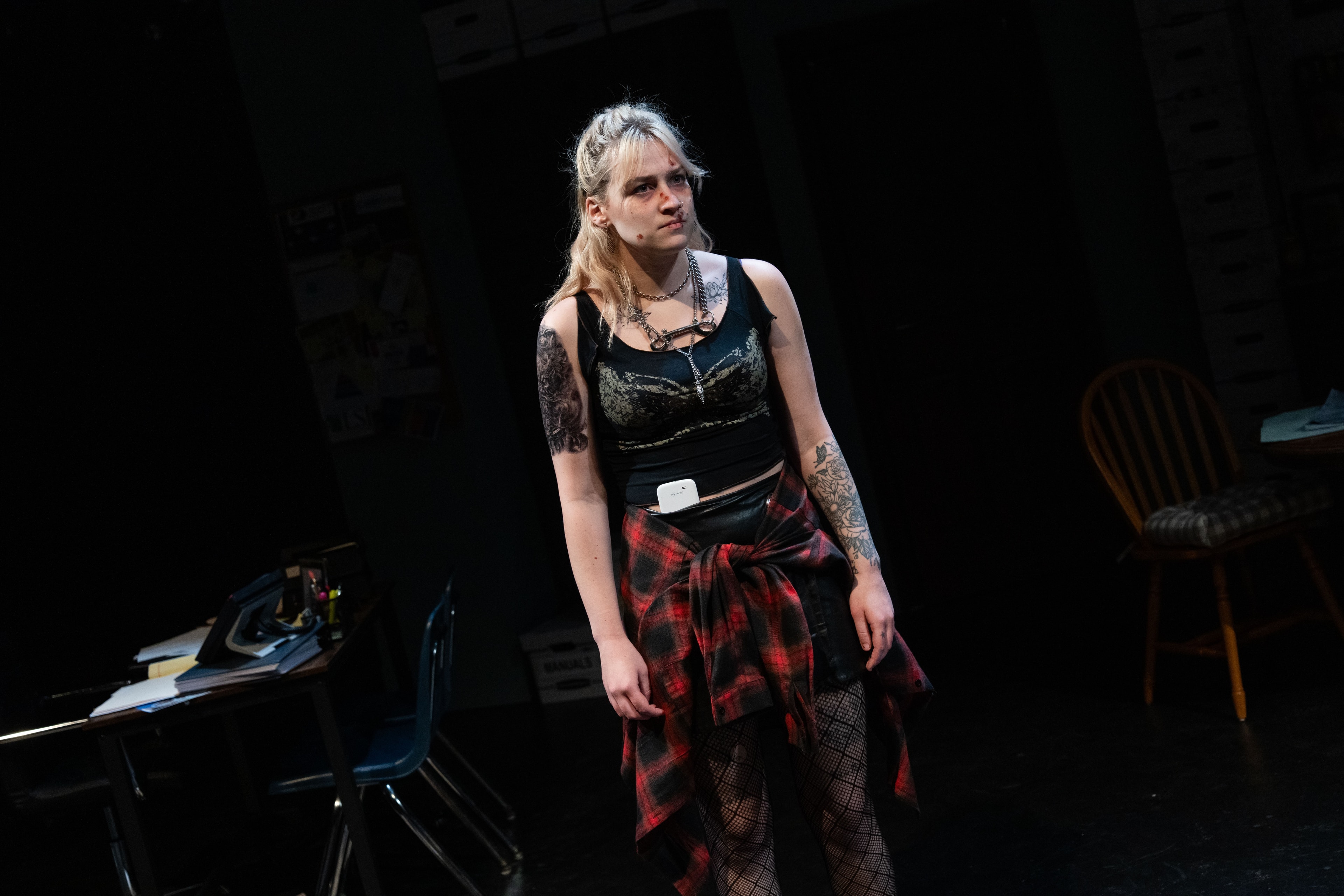 Lex Leone on stage in plaid skirt standing alone
