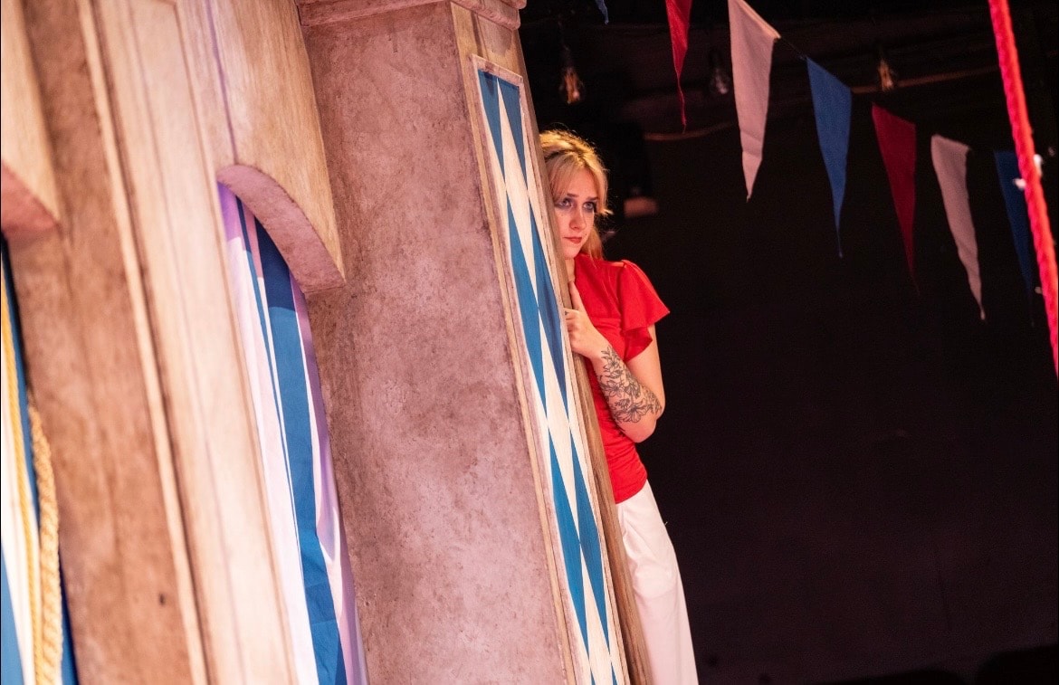 Lex Leone peering around a column on stage