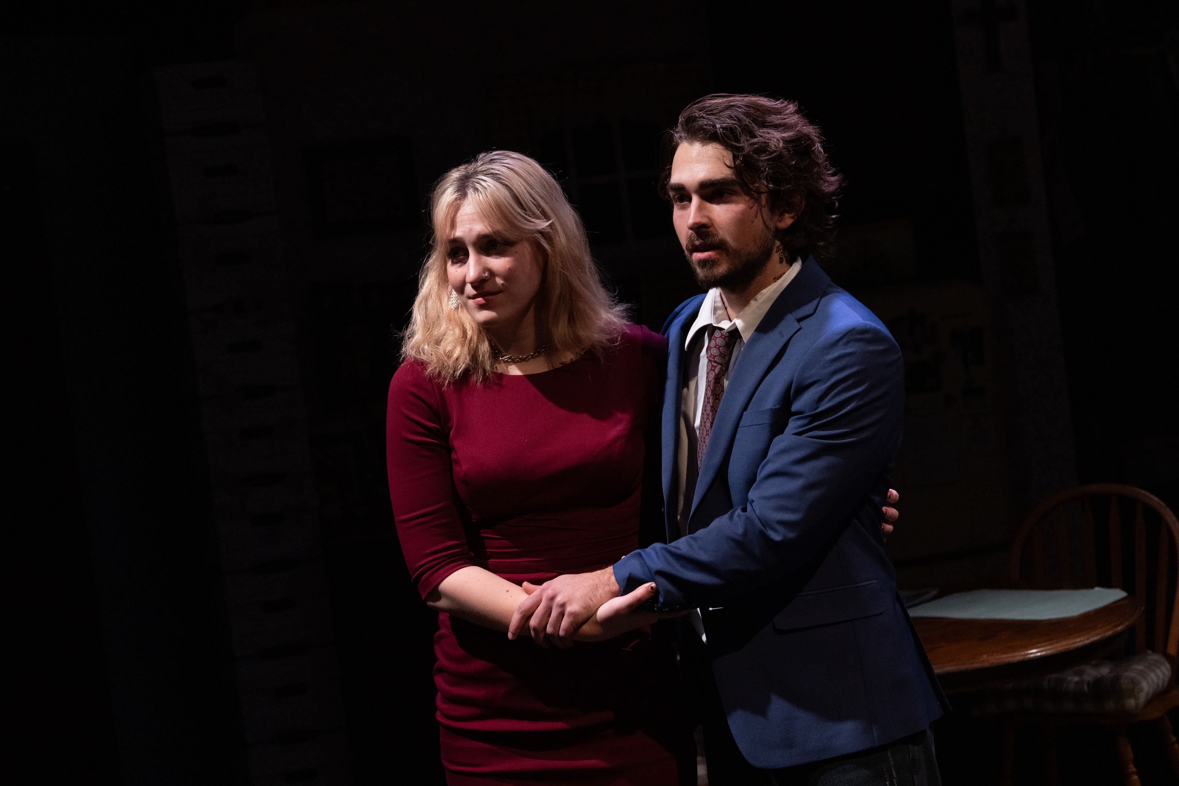 Lex Leone on stage in plaid skirt confronting seated co-star