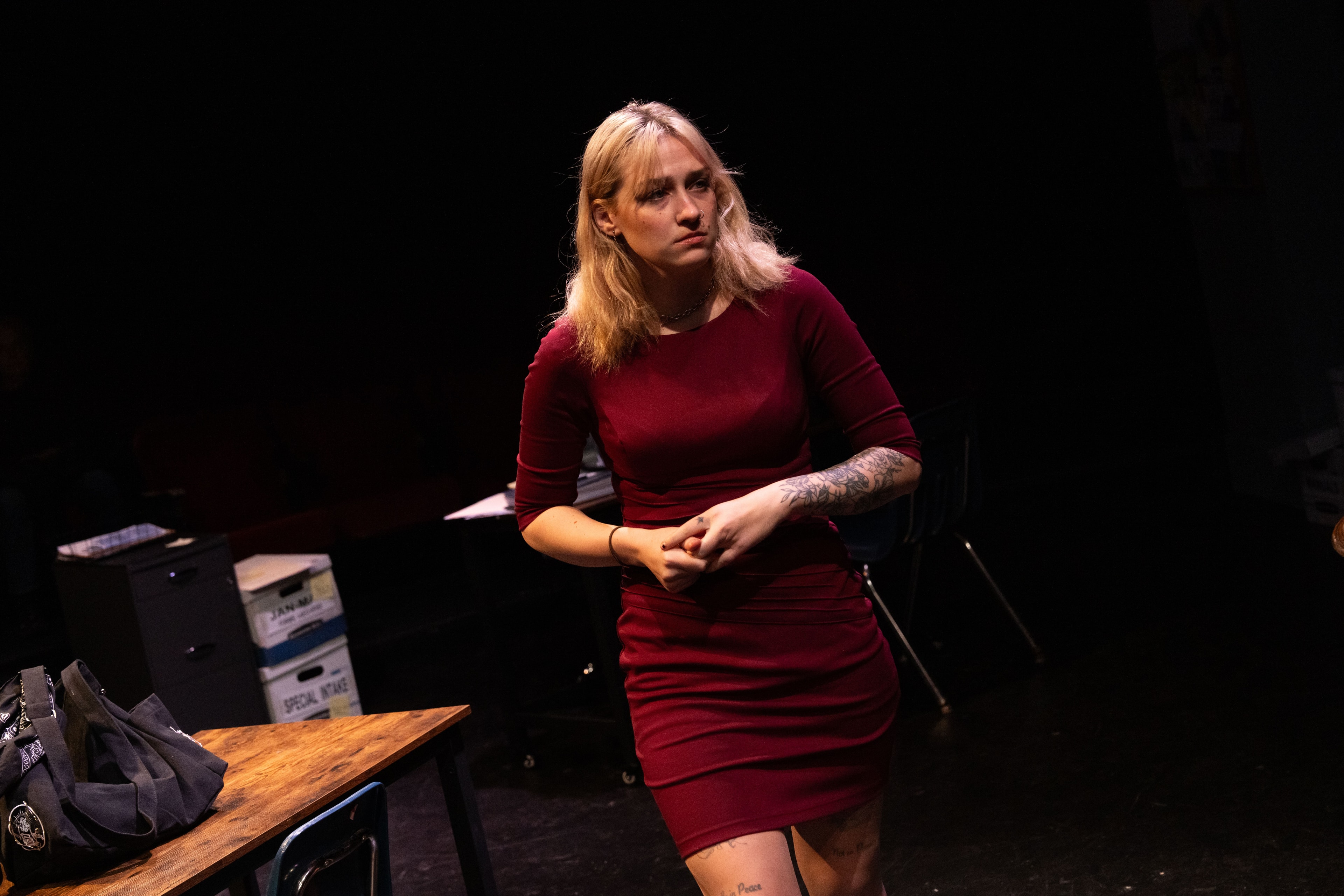 Lex Leone on stage in burgundy dress standing alone