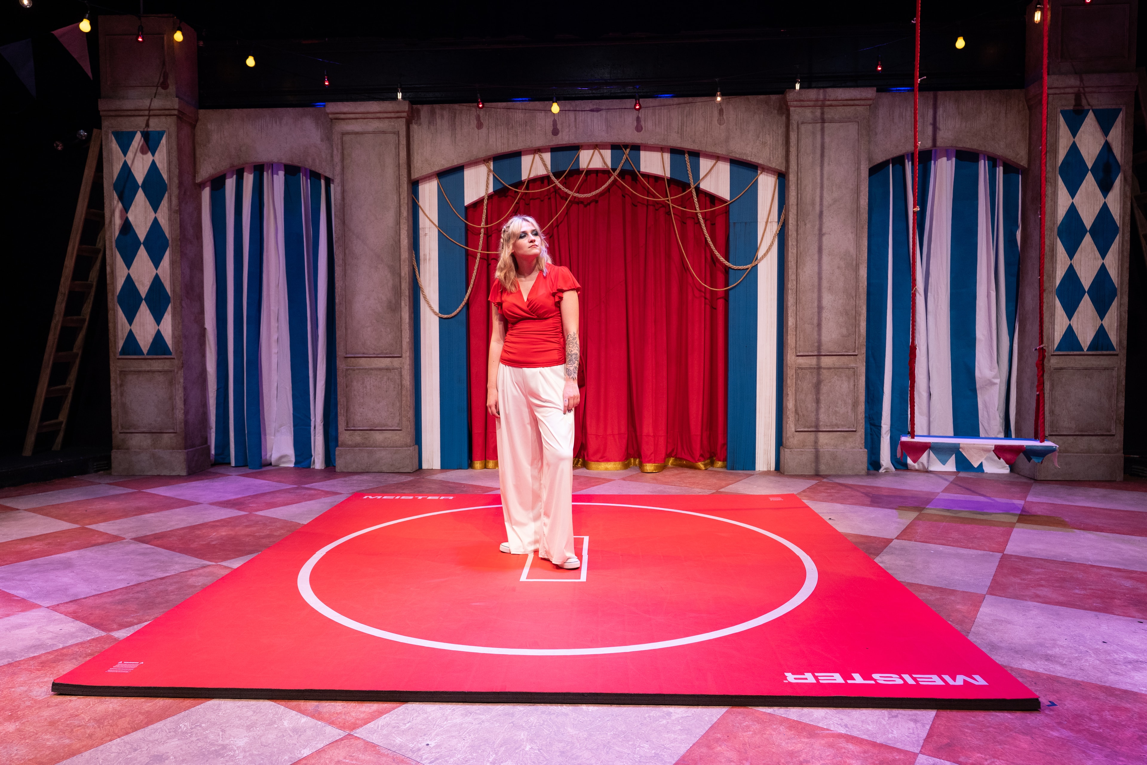 Lex Leone on stage standing on red mat